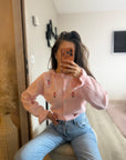 Cardigan rose avec détails floraux